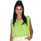 Woman wearing a bright green sleeveless top on a white background