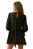 Black romper with long sleeves and open back on white background