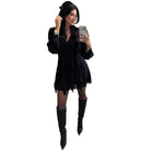 Woman in a black romper with knee-high boots taking a selfie on a white background