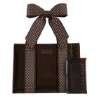 A brown tote bag with white polka-dot handles and a matching clear phone case with a large bow, both branded CASE-MATE, shown on a plain white background.