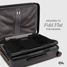 Black suitcase with a flat-packable feature on a light gray background