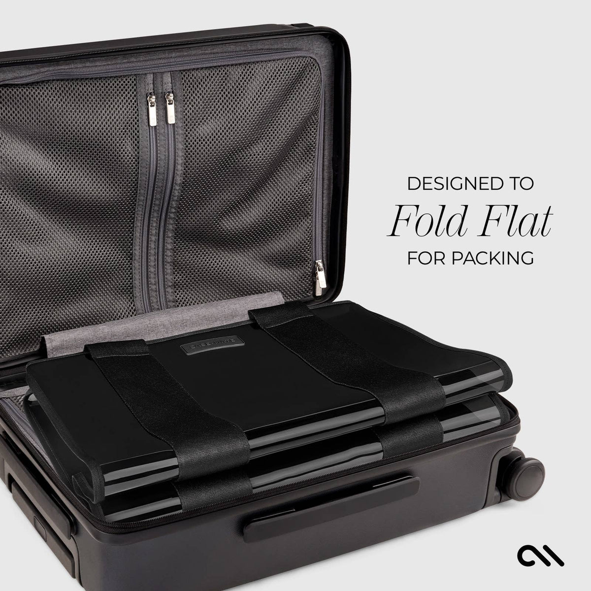 Black suitcase with a flat-packable feature on a light gray background