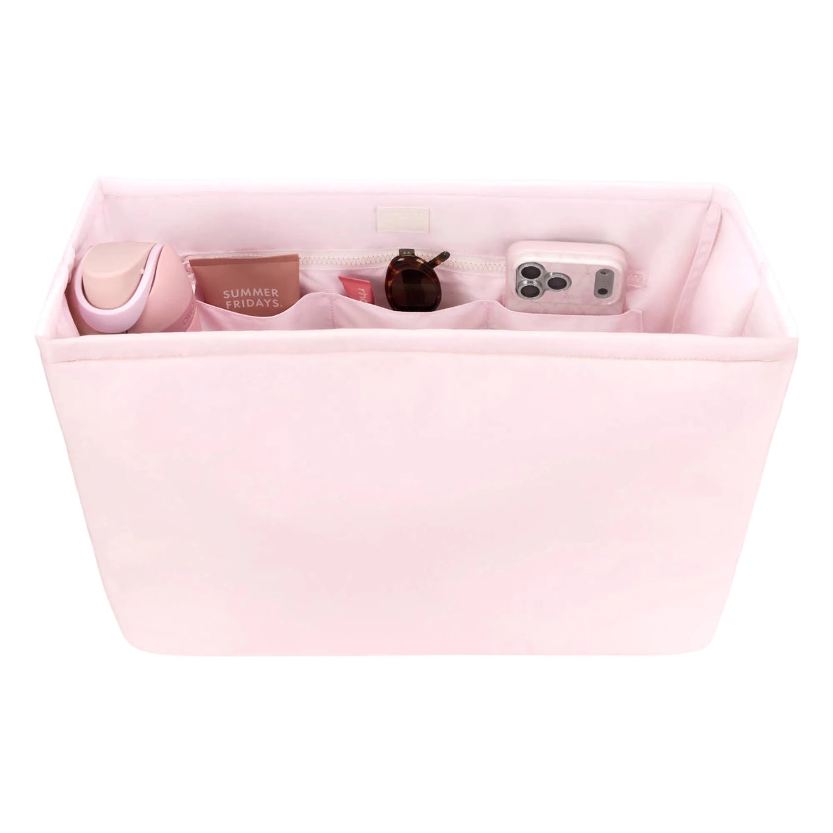 Pink organizer bag with compartments containing various items on a white background