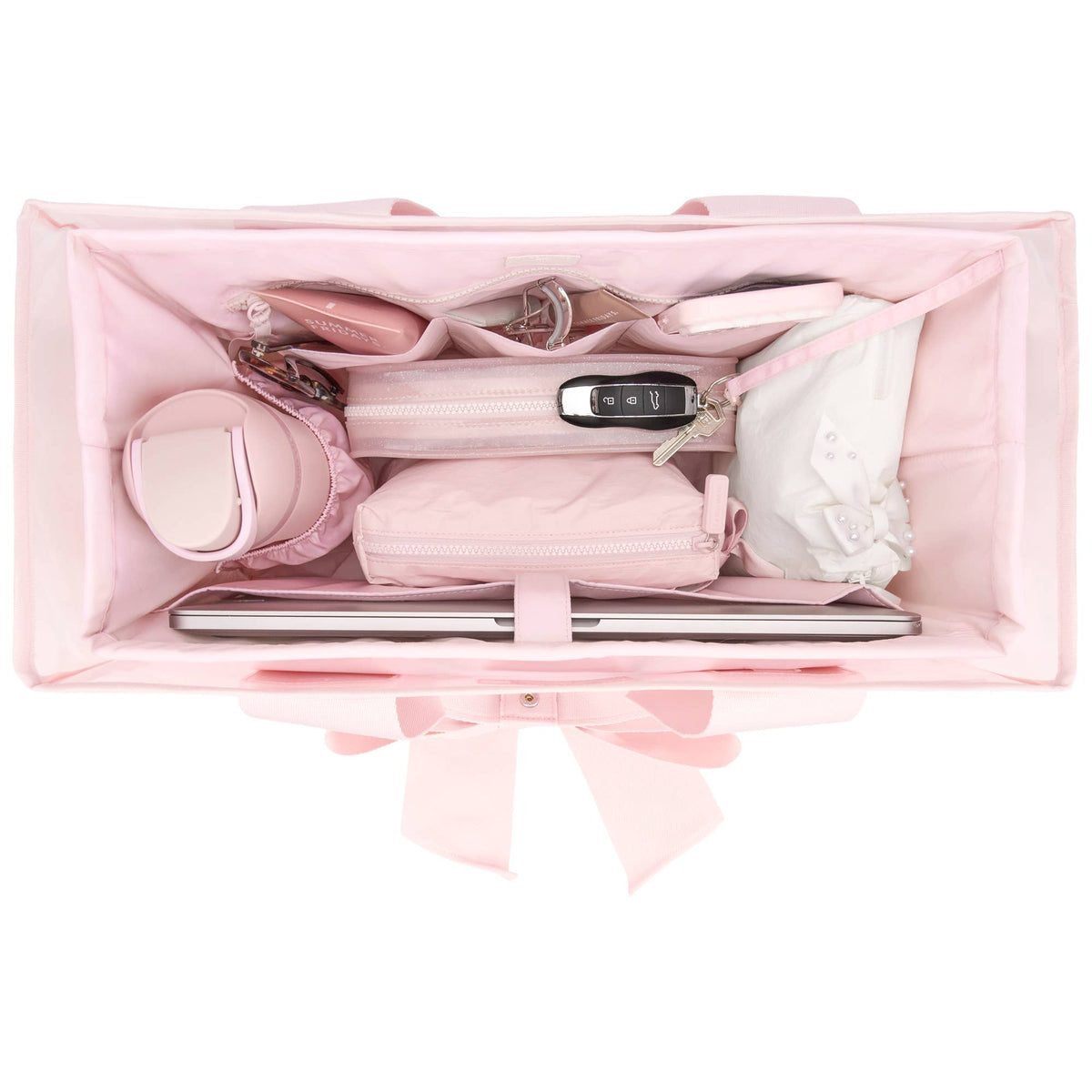 Pink makeup bag with various cosmetic items on a white background
