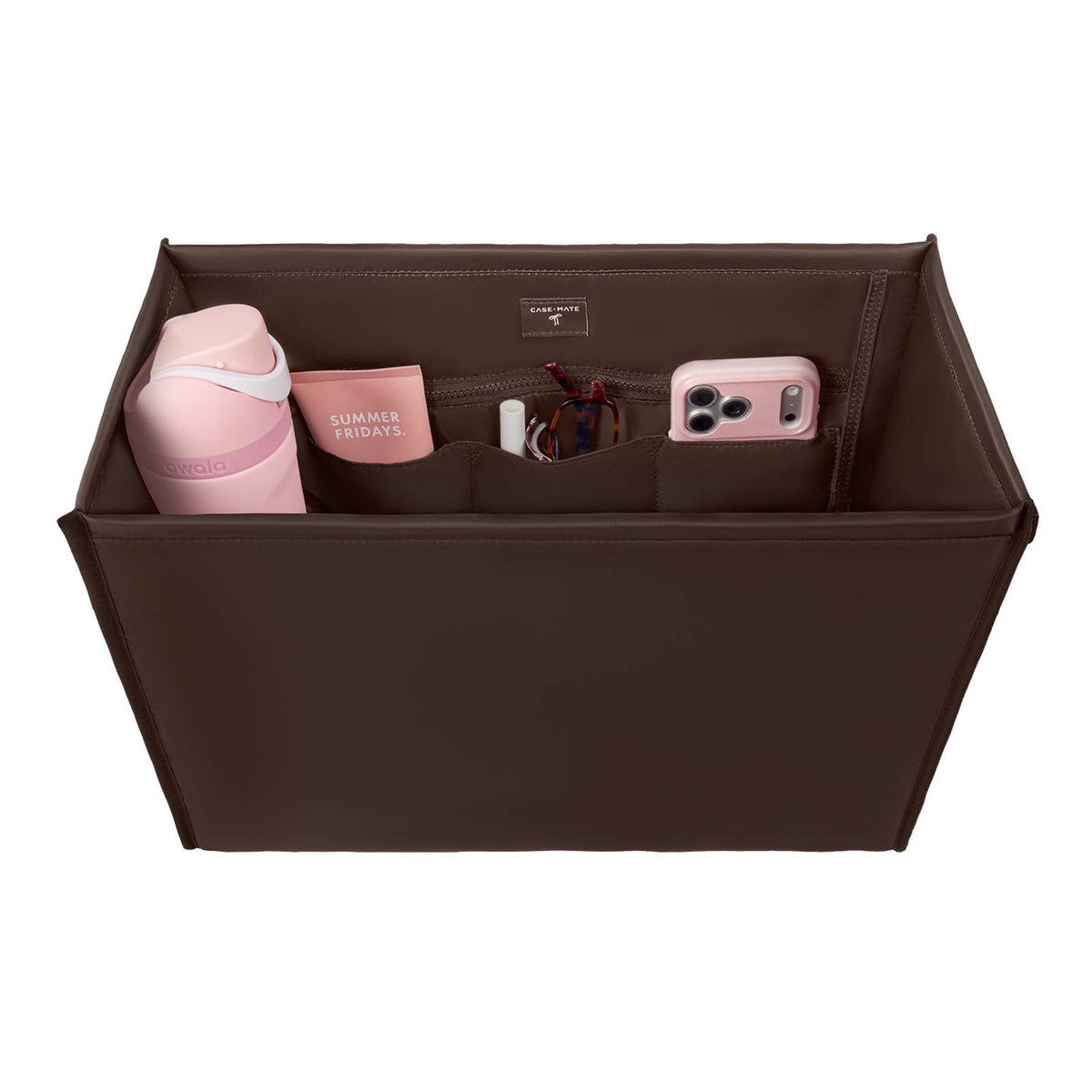 A brown fabric organizer bag with multiple compartments, shown from a top-down view on a white background. The organizer is styled with various pink and white items, including a water bottle, a phone case, and a small card holder.