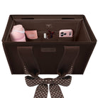 A brown fabric car organizer bag with a matching polka-dot bow, shown open to reveal interior pockets holding a pink bottle, mug, cord, and phone. The bag has a visible 'CASE-MADE' label and is photographed on a clean white background.