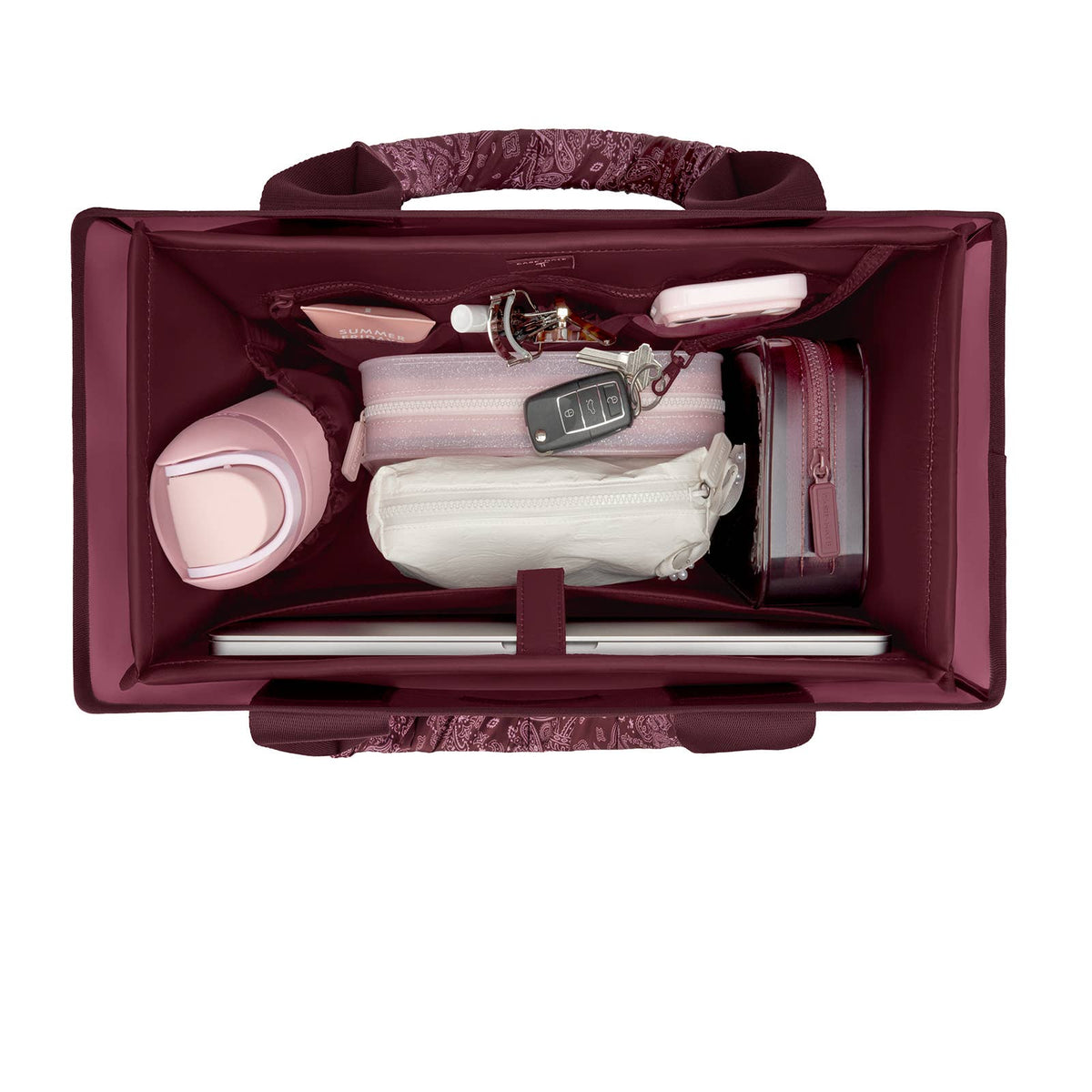 An open burgundy laptop bag with a patterned handle and interior organizer pockets, shown from a top-down view with various travel accessories and a laptop packed inside on a white background.