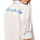 woman wearing white button down cover up that says "Catch of the Day" on the back