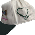 Cap with heart design and text on a white background
