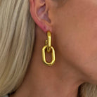 Gold hoop earring worn by a person with blonde hair.