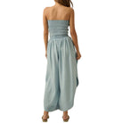 Woman wearing a strapless light blue jumpsuit on a white background