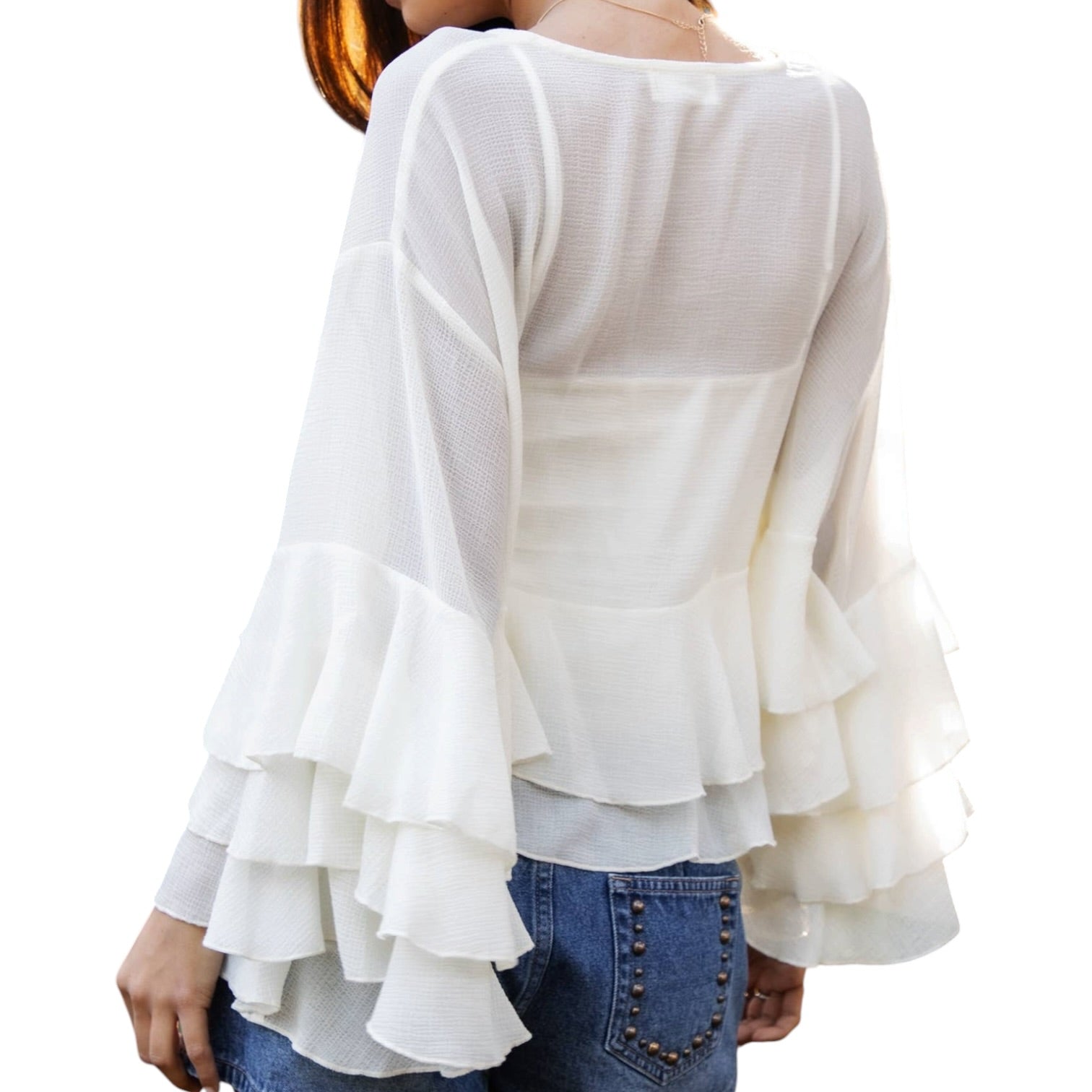 White ruffled blouse worn by a person on a white background