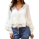 White ruffled blouse worn by a person on a white background