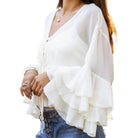 White ruffled blouse worn by a person on a white background