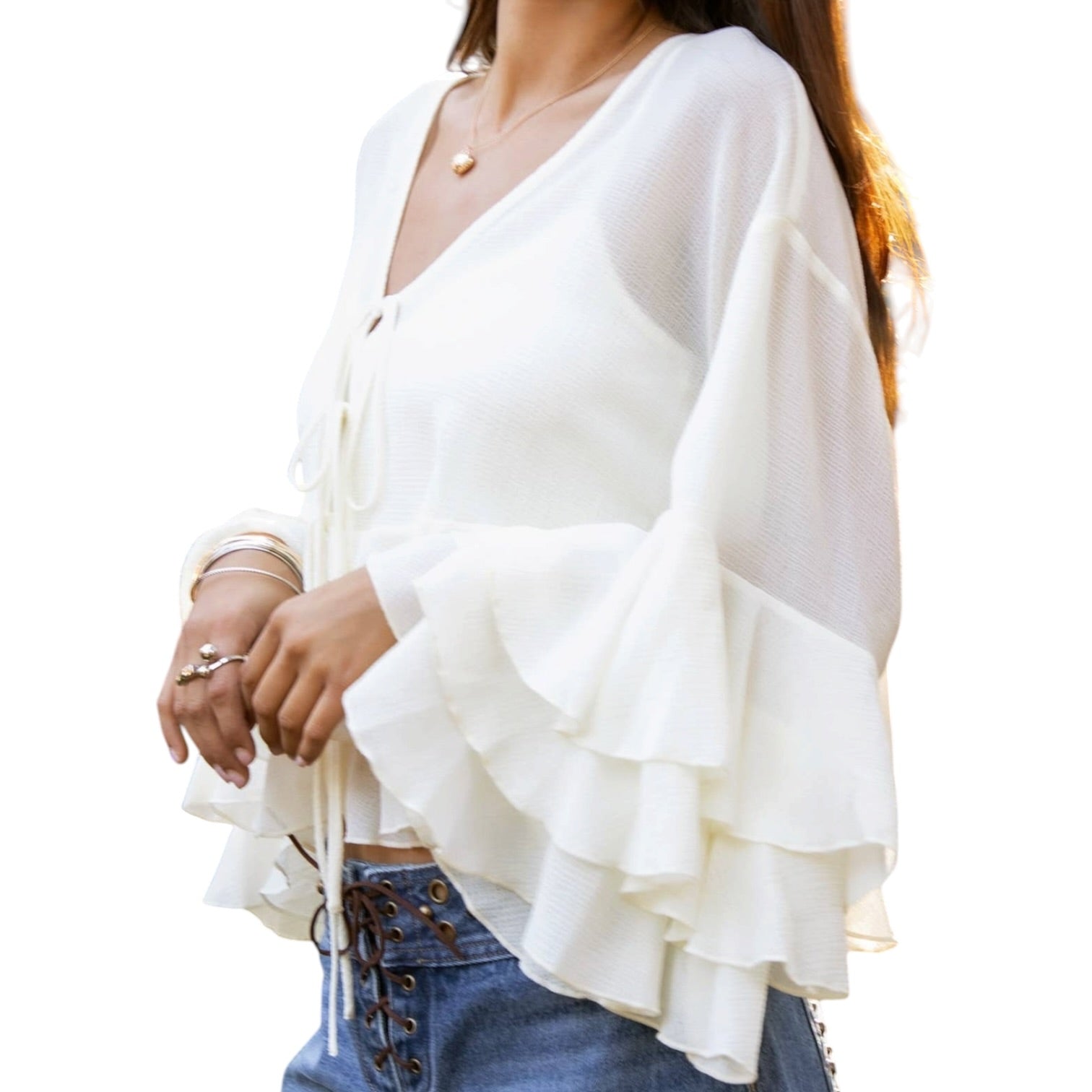 White ruffled blouse worn by a person on a white background