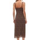 Woman wearing a leopard print slip dress on a white background