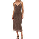 Woman wearing a leopard print slip dress on a white background