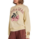 Beige sweater with 'Dolce Vita' and cherry design, worn by a person.