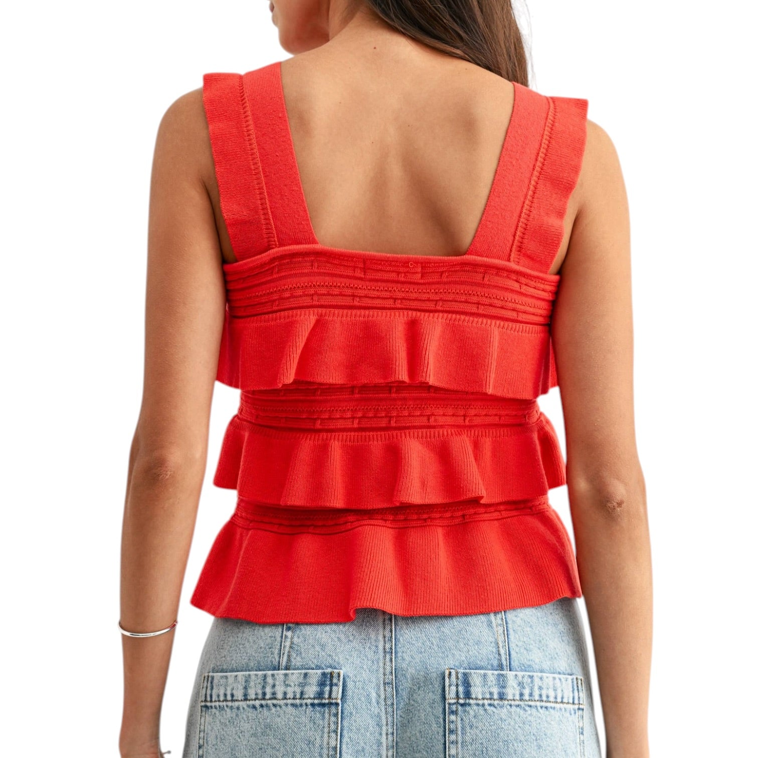 Red ruffled top worn by a person on a white background