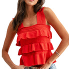 Woman wearing a red ruffled top on a white background