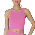 Woman wearing a pink sports bra and leggings on a white background