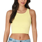 Woman wearing a yellow crop top on a white background