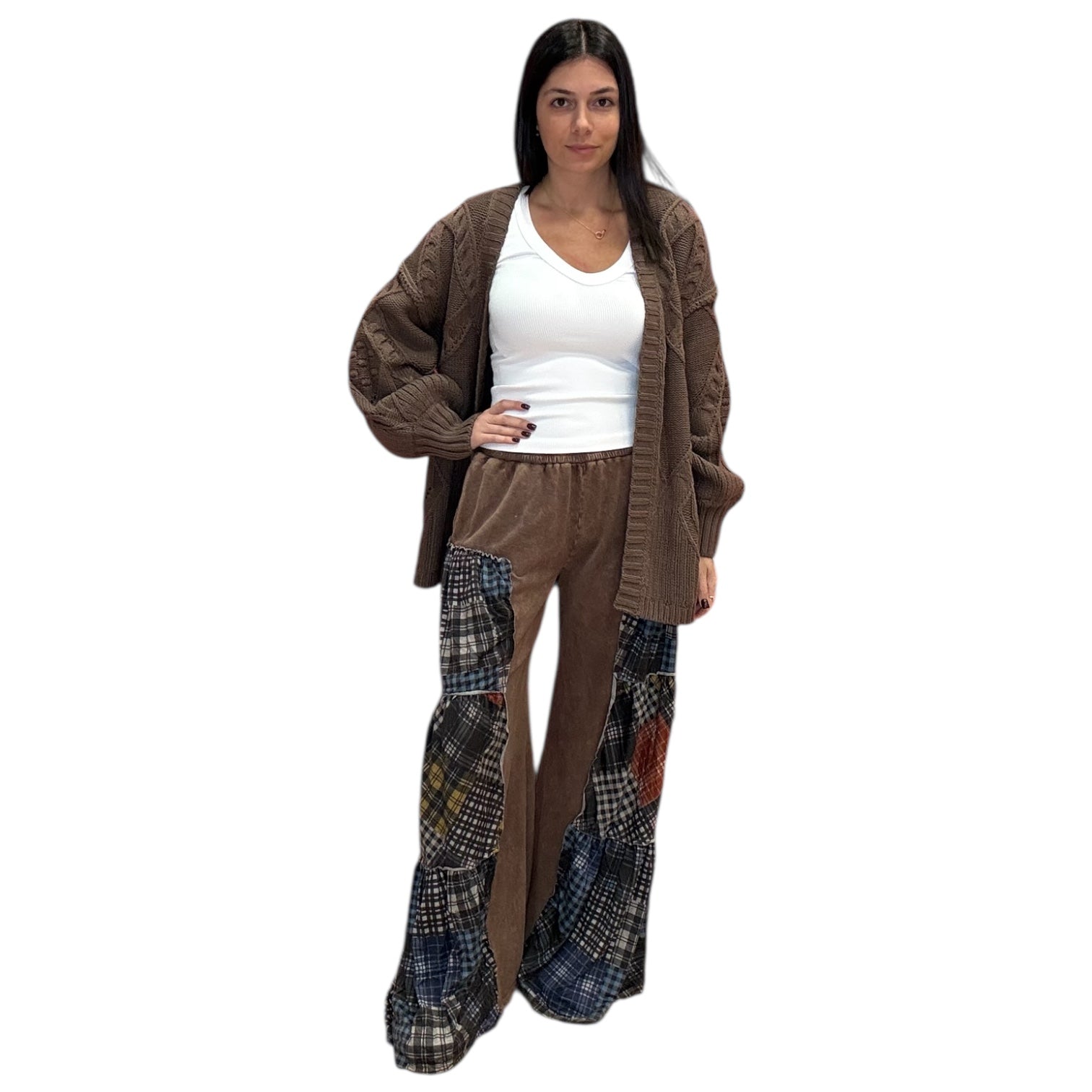 Woman wearing a brown cardigan and plaid pants on a white background