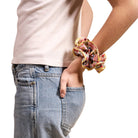Person wearing a floral scrunchie on a white background