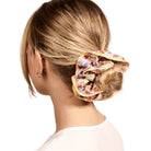 Woman with floral scrunchie in her hair on a white background