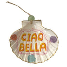 A decorative shell-shaped ornament with the words 'CIAO BELLA' in orange lettering, decorated with small colorful seashell motifs and a hanging string with a green bead, shown on a plain white background.