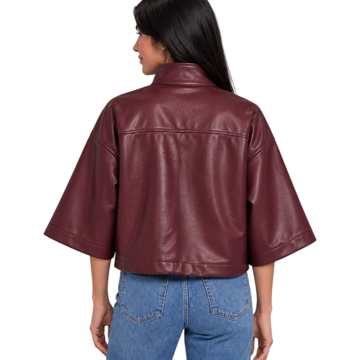 A woman shown from the back wearing a cropped, wide-sleeved faux leather jacket in a deep burgundy color, paired with blue jeans, against a plain white background.