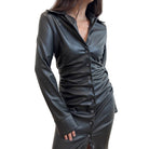 Black button-up dress worn by a person on a plain background