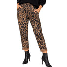 A person wearing leopard-print ankle-length pants with a drawstring waist and cuffed hems, paired with black pointed-toe ankle boots against a plain white background.