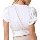 White crop top worn by a person on a white background