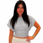 Woman wearing a gray top and beige pants on a white background