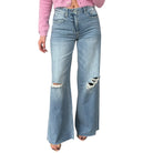 Ripped blue jeans worn by a person on a white background