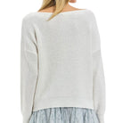 White off-shoulder sweater with a light blue ruffled skirt on a white background