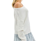 White off-shoulder sweater with a light blue ruffled skirt on a white background