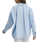 Person wearing a light blue and white striped shirt on a white background