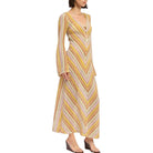 Woman wearing a long, patterned dress on a white background