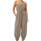 woman wearing taupe jumpsuit on white background