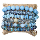 Stack of blue beaded bracelets on a textured surface