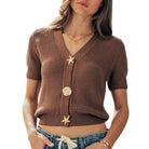 Woman wearing a brown knitted cardigan with shell and starfish decorations on a white background