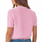Pink knitted cardigan worn by a person on a white background