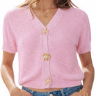 Pink knitted cardigan with starfish and shell buttons on a white background