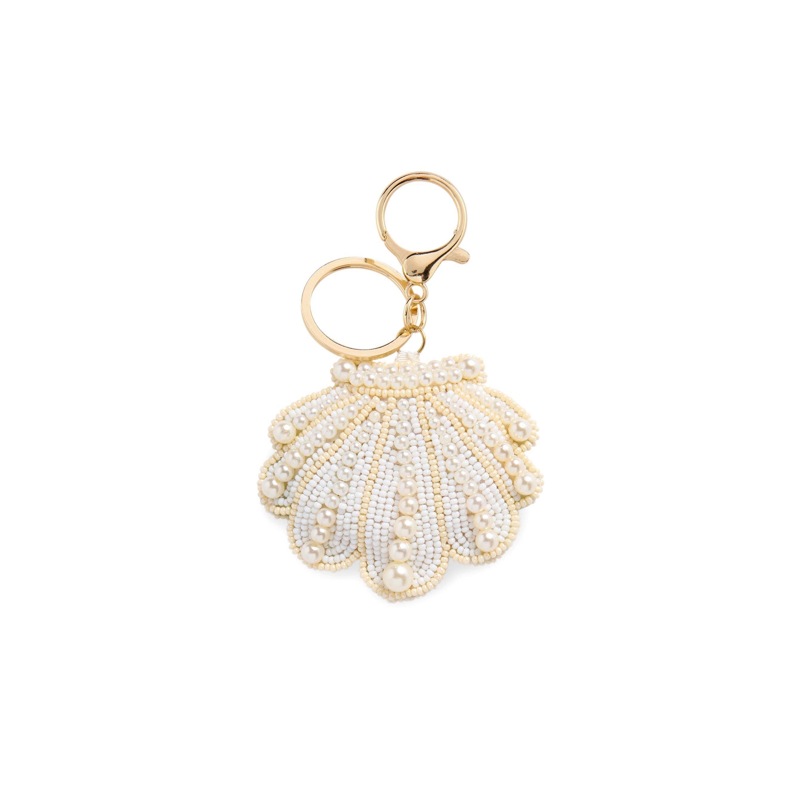 Shell-shaped keychain with gold and white details on a white background