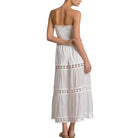 Woman wearing a white strapless dress with lace details on a white background