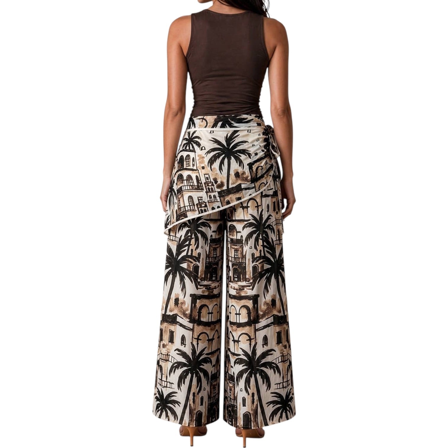 Woman wearing a sleeveless brown top and patterned wide-leg pants with palm tree design on a white background