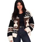 A woman modeling a black, brown, and cream knit cardigan with Fair Isle patterns, worn over a black top and dark blue jeans against a plain white background.
