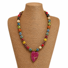 Colorful beaded necklace with a heart-shaped pendant on a mannequin bust.